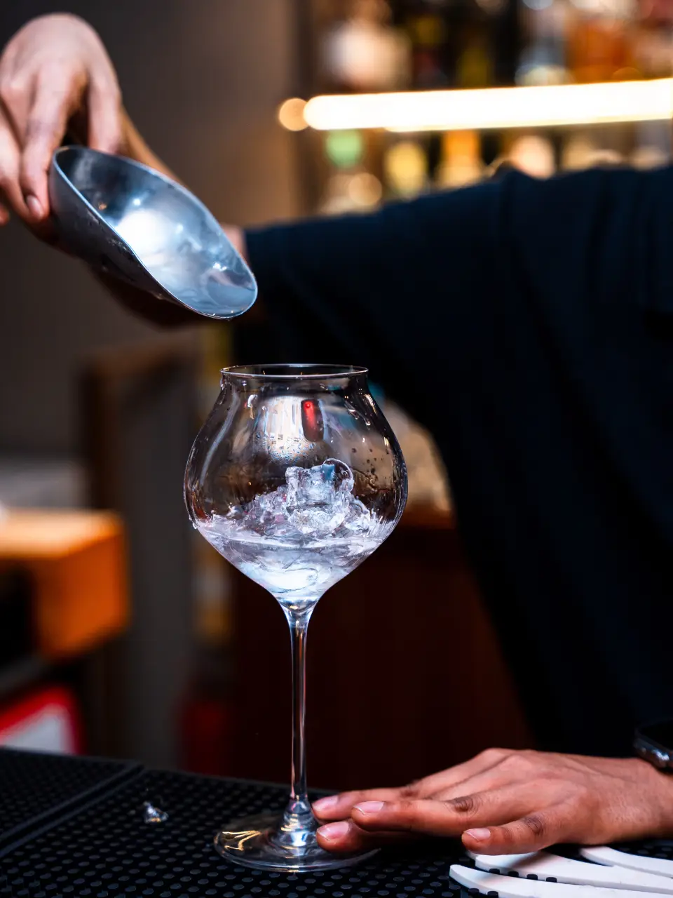 Ice scooped into a balloon glass at the bar