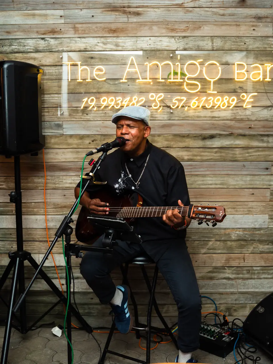 A singer and guitarist playing live under the Amigo neon