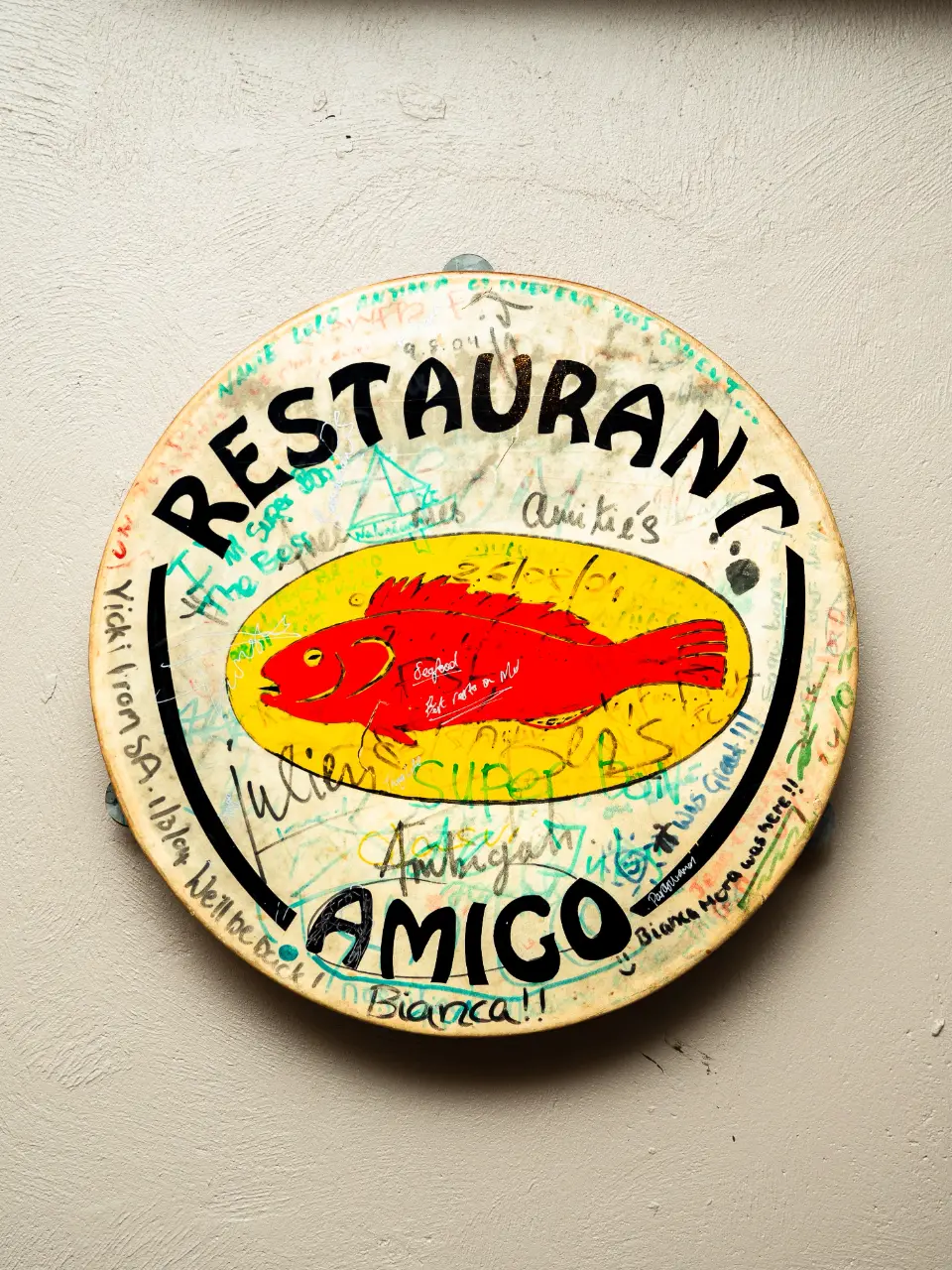The hand-signed Restaurant Amigo drum on the wall, covered in guest messages